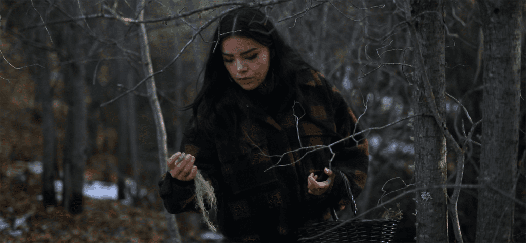A woman gathers lichen in the forest to make soap out of