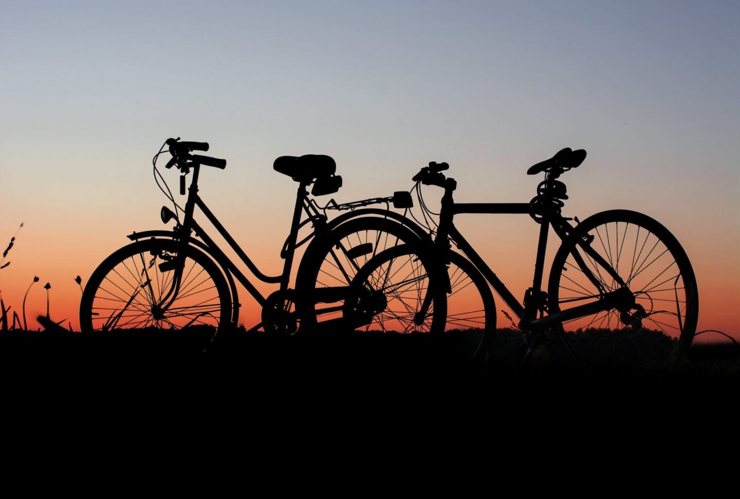 Silhouetted bicycles against a sunset