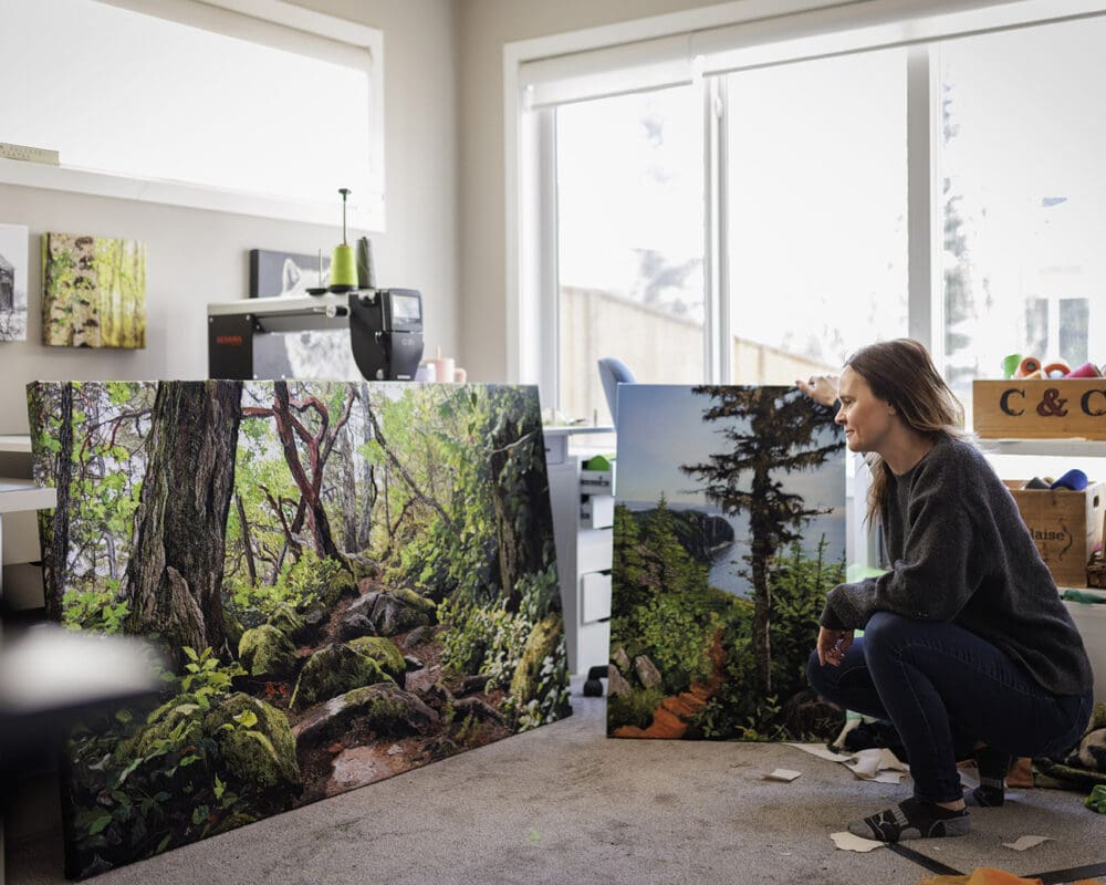 Artist Alison King squats in front of her art in her study